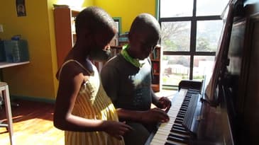 Learning to play piano in South Africa! Globe Aware