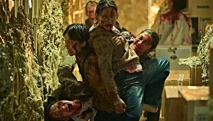 Korean zombies clump together in a sneering cluster moving through a goo-drenched warehouse in Colony.