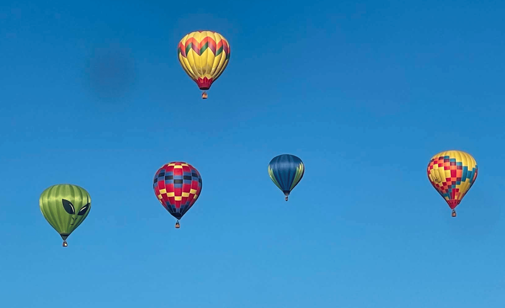 5 hot air balloons with blue sky background