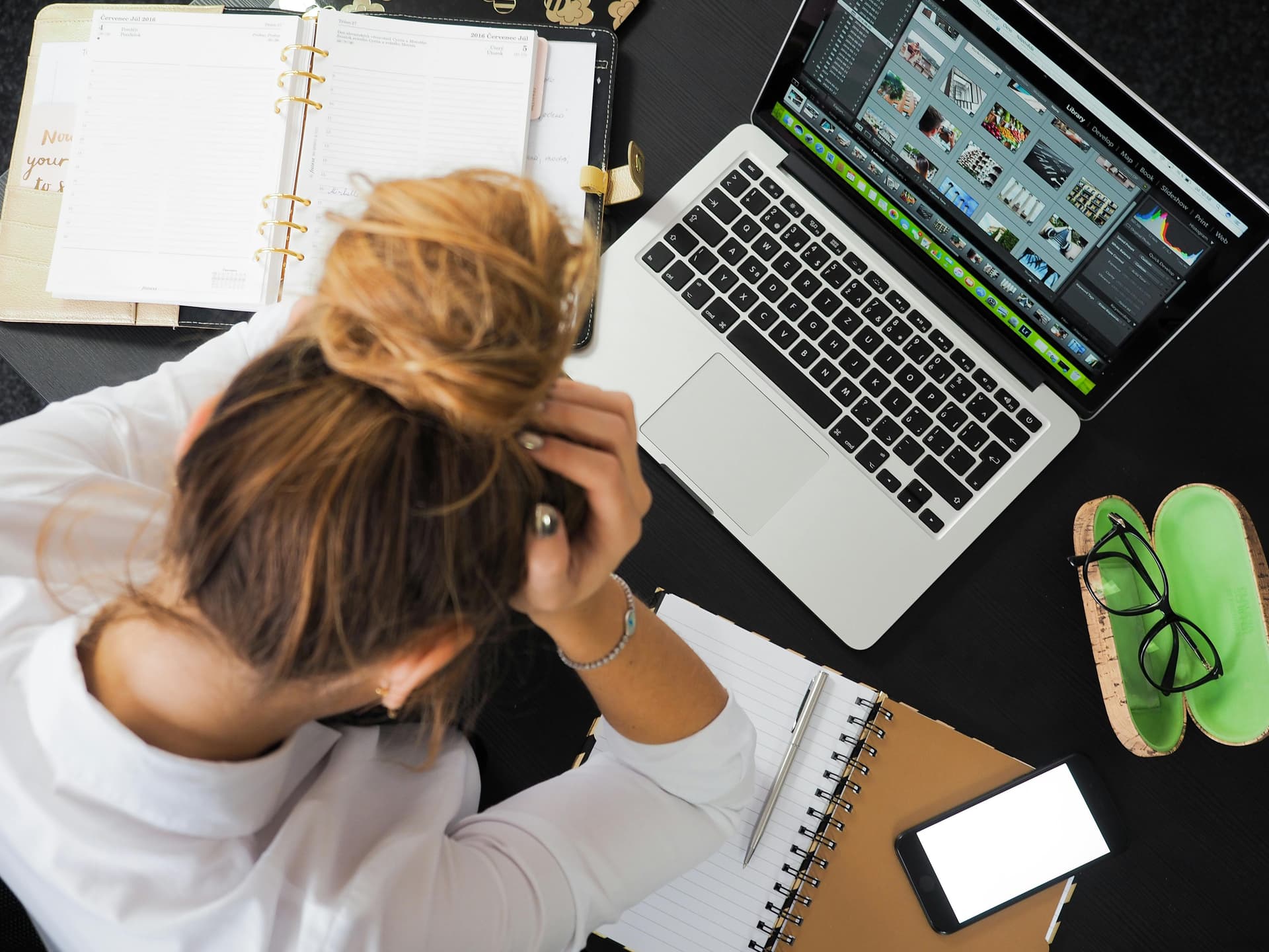 women with head in hands at a laptop