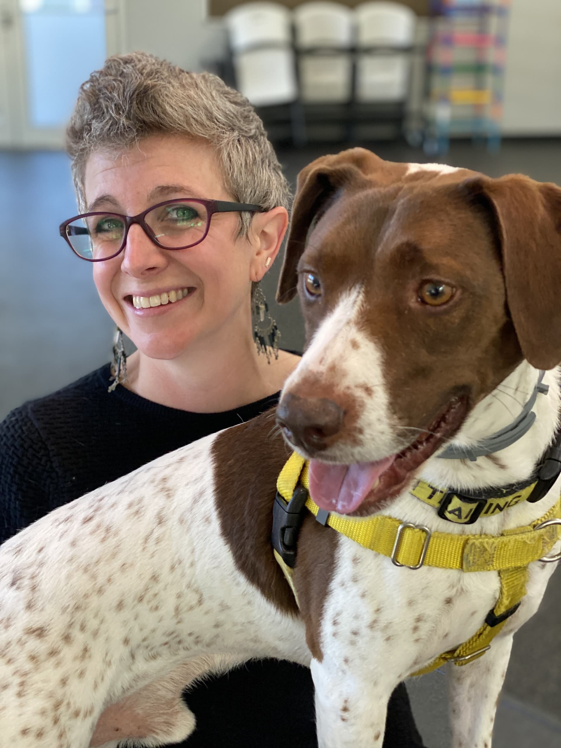 A woman with short grey hair with a brown and white dog