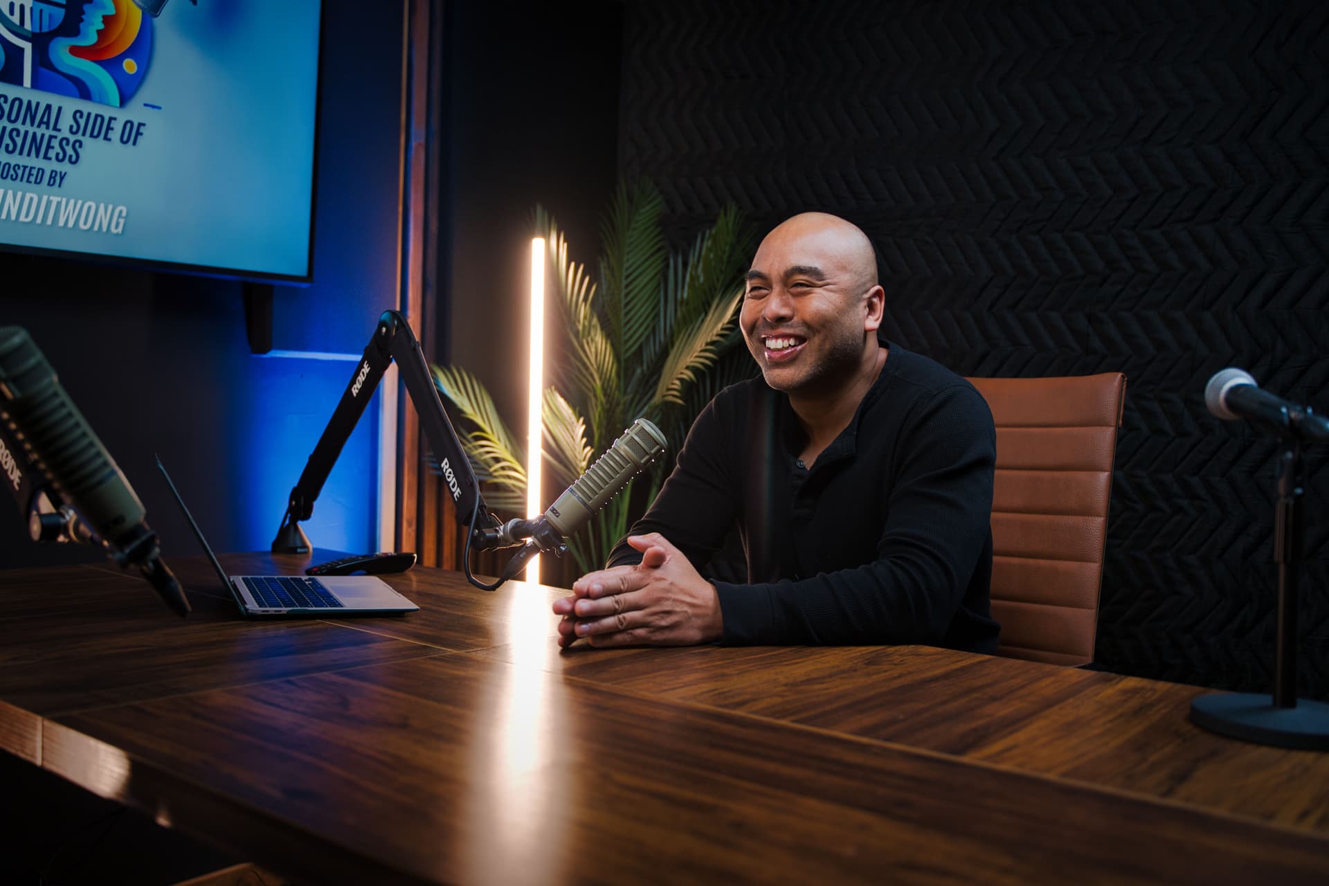 Jet Bunditwong at the mic, speaking with an entrepreneur guest in a podcast studio