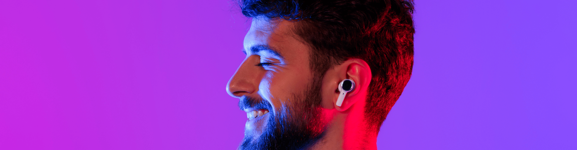 smiling man listening to audio in earbuds