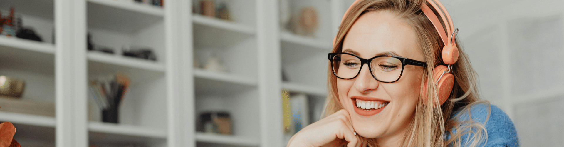 smiling woman listening to audio in headphones